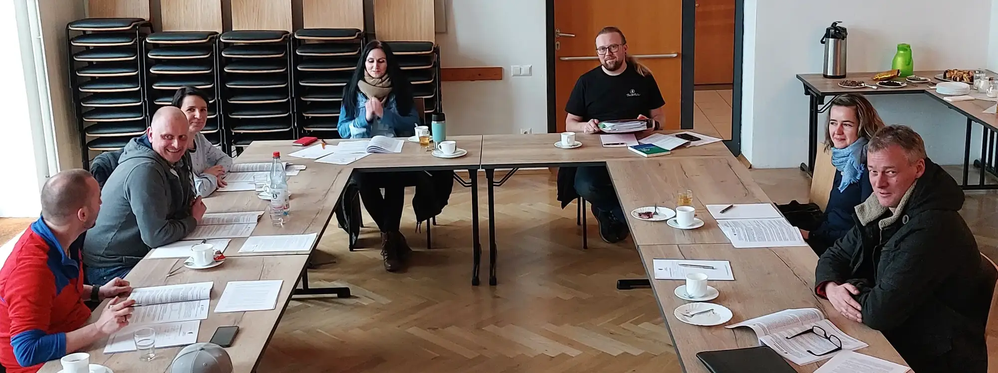 Teilnehmer mit Weiterbildungsunterlagen am Tisch